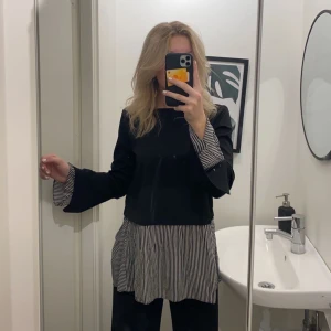 Svart blus st xs - Svart långarmad blus med insydd skjorta under, jätte skön och bra kvalitet. Frakt betalas av köparen.