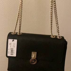 Äkta guess väska - Säljer en guess väska som inte är använd, prislapp finns kvar. Fler bilder vid intessse! Kan även gå ner i pris vid snabb affär