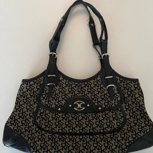 Dkny väska  - Säljer min fina Dkny väska. Superfin och äldre modell. Har ett magnetfack både inuti och på framsidan som man ser på första bilden. Axelbanden går att reglera och väskan är i fint skick. Den har en liten fläck på baksidan (se sista bilden) men annars är allt fräscht.             HÖGSTA BUD: 450kr