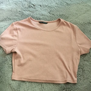 Rosa topp - En rosa croppad topp. Toppen är i ett ribbat material. Aldrig användt på grund av att jag inte gillar passformen. Toppen är helt som ny.