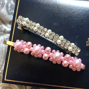 Klämmor  - 2 klämmor, en med rosa pärlor och en med silvriga diamanter och vita pärlor, den rosa är aldrig använd och den silvriga är använd några få gånger. Jag säljer dem båda för 25kr inklusive frakt 🥰💓