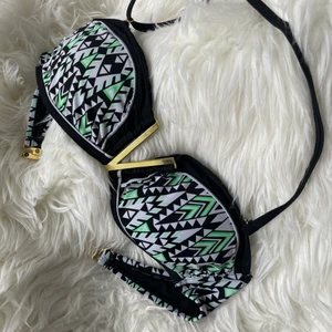 River Island bikinitopp - Säljer denna snygga bikinitopp då den inte passade. Aldrig använd. Ingen bygel i men ett guldigt metall ”V” i mitten som det syns på bilden vilket ger toppen mer stabilitet. 