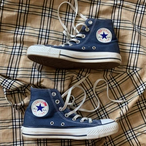Blå converse  - Blåa converse all star i storlek 37, mäter 23,5 cm. Praktiskt taget oanvända så väldigt fint skick med ingen påverkan på gummit eller tyget. Enda anmärkningen är att röda loggan löst upp sig lite, se bild tre. Skicka PM vid eventuella frågor eller fler bilder. Köparen står för frakt 🚚 🏀 