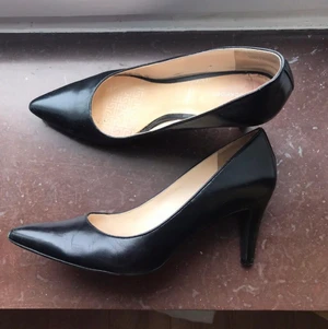 Skinnpumps 39 - Stl 39 svart skinn. Något små synliga slitage vid spetsen och klacken, se bild.