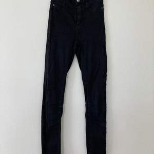 Ett par svarta tajta jeans från Gina tricot 