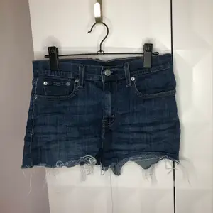 These jeans shorts are like 501-but better. There is some stretch, and they are mid to high waist. No stains or damage. 99% cotton, 1% elastane, machine washable