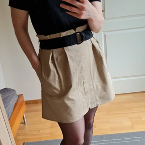 Paperbag skirt with belt - Paperpag beige skirt from Mango with black belt and practical pockets. Zipper fastening in the back. Material made of 100% cotton so it is perfect for spring and summer ☀️ Waist 35 cm, total length 45 cm.