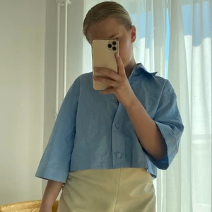 Blå croppad skjorta  - Blå kort skjorta i nytt skick med prislappen kvar. Köpte förra sommaren men inte använt den något. Normal i storleken. 