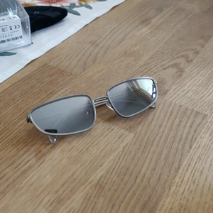 Solglasögon - Solglasögon med spegelreflektion på glasen. Från Weekday. Fraktkostnaden tillkommer.