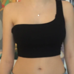 svart linne med ett strap  - Snyggt Svart linne med ett strap på vänster sida. Storlek S. Frakt tillkommer eller mötas på Södermalm:)