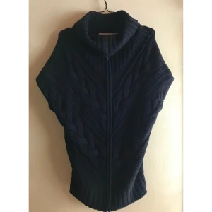 Tiger Of Sweden stickad väst mörkblå ull - TIGER OF SWEDEN “Ina” oversize mörkblå fint stickad långväst kofta i ull. Jätte oversize Storlek XS, passar alla storlekar Fint skick, lite ull nopprig Zip hela vägen, kan ha denna som varmt polonacke eller öppnad. Längd: 73cm  *RÖKFRI OCH DJURFRI HEM*