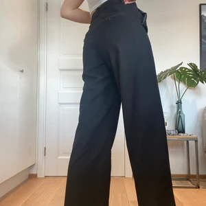 Kostymbyxor - Svarta kostymbyxor från Nakd. Höga i midjan och vida ben. Lagom långa i benen för mig som är 170 cm.