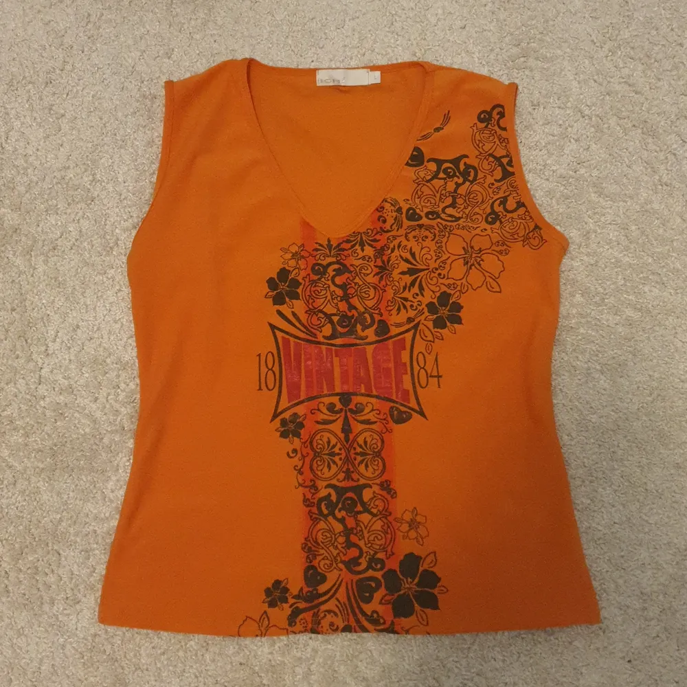 Ett oranget vintage-linne från ICHI. Storlek L men passar på S och M. Bra skick. Material: polyester/elastin. Skriv vid intresse!. Toppar.