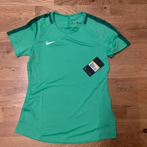Nike tröja - Helt oanvänd och nyinköpt träningströja från Nike, underbar grön färg men den kom inte till användning som jag tänkte då jag har för många toppar