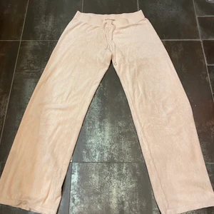 Moderna mjukisbyxor från Juicy Couture. - Ett par superfina och trendiga ljusrosa mjukisbyxor från det populära märket Juicy Couture. Byxorna har en rak modell och är i storlek M.