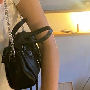 Väska - Säljer en väska med okänt märke men aldrig använd. Den har en kedja som går över axeln men mankan även hålla den!