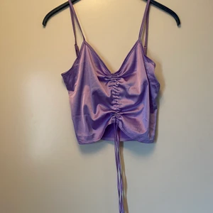 lila linne - Jättegulligt lila linne från empty soda, dragskon i mitten gör att man kan ha den antingen som en magtröja eller som ett längre linne! jätte skönt material