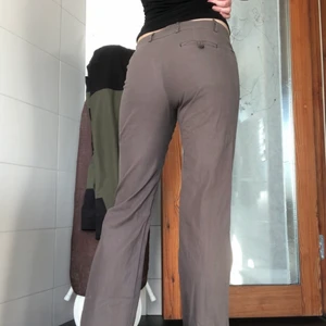 Kostymbyxor - Grå/bruna kostymbyxor i midwaist. Sitter okej på mig som är 174cm. Midjemått: ca 82cm Innerbenslängd: ca 80cm