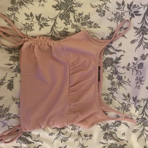 Topp - Säljer denna jätte fina sommartoppen men fina detaljer då den är lite för liten över mina bröst. Går att justera på sidorna hur långt upp man vill att den ska gå osv. Ribbat stretchigt bra material. Använd Max 2 gånger säljes i storlek S.