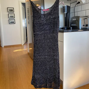 Glittrig klänning - Glittrig klänning från Indiska. Den är stickad och ganska genomskinlig så passar bra antigen på stranden eller med en underklänning under. Strl M sitter tajt på mig.