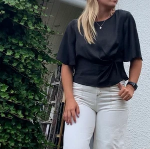 Svart silkesblus - Svart silkesblus med detalj vid midjan och volangers ärmar! Super fin vid lite festligare tillställningar! 