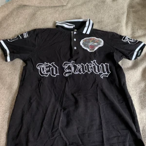 Ed hardy piké strlk S/M - Ed Hardy piké av Christian Audigier. Säljer eftersom den är för liten. Storlek S/M. Jag är 176 och den är lite för liten på mig. Gott skick, inga synbara fel. 