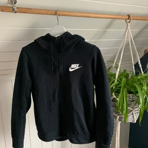 Nike huvtröja med dragkedja  - Svart Nike tröja med dragkedja. Hög krage och text på ryggen. Tröjan är i storlek S men är något kort i ärmarna, passar snarare som XS💙