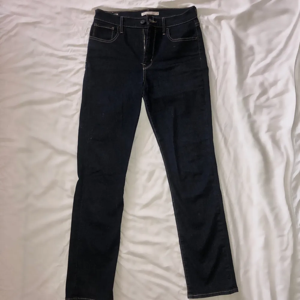 Levis 724 high rise straight legged jeans. Mörkblå med gul söm. Köpta för runt ett år sedan. Använda några få gånger & super bra skick. Väldigt stretchigt tyg. Nypris -1000 ✨ (har inga bilder hur som sitter på mig eftersom försmå.) buds i dm. Jeans & Byxor.