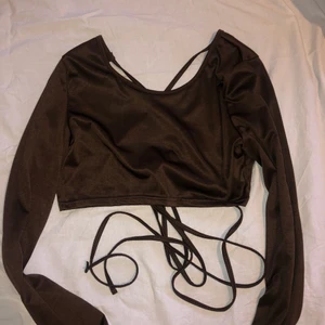 Brun topp med snörning - Oanvänd. Snören är ca 2 meter långa på varje sida och knyts efter eget smaktycke. Ganska liten vid brösten. 