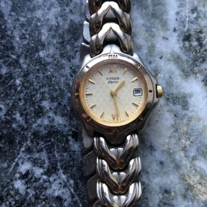Citizen damklocka - Fint klockmärke mee mycket detaljer. Guldig urtavla med snyggt silvermänstrad armband som har nyanser av guld. Nypris 899:-. Batteribyte behövs.