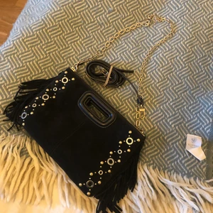 Maje väska  - Säljer denna assnygga väska från Maje då den ej kommer till användning. Svart matt med silver och guldiga detaljer, i mycket fint skick. Svart band ingår ( inte kedja) Bud från 800 kr 