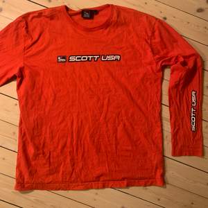 En långärmad röd t-shirt med Scott Usa på bröstet och ena ärmen. Storlek L så sitter baggy. Köpt second hand men säljer för att den inte kommer till användning.