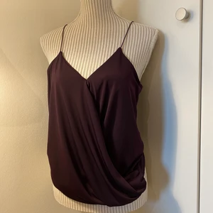 Topp Gina tricot  - Omlott linne från Gina tricot i en mörk lila färg. Strl S men passar säkert M också☺️