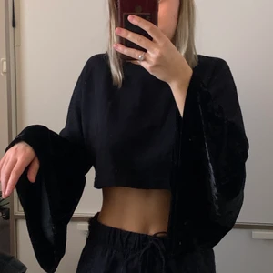 Svart tröja - En svart tröja med stora ärmar, den är lite kroppar och har två olika material på ärmarna och kroppen. 