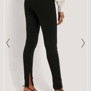 Svarta byxor med slit från NA-KD - Väldigt fina svarta byxor med slit använda ett par gånger pris går att diskuteras. Små i storleken 