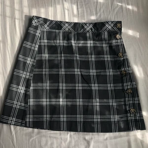 Svart kjol pläd - Säljer min fina pläd kjol med knappar på sidan.