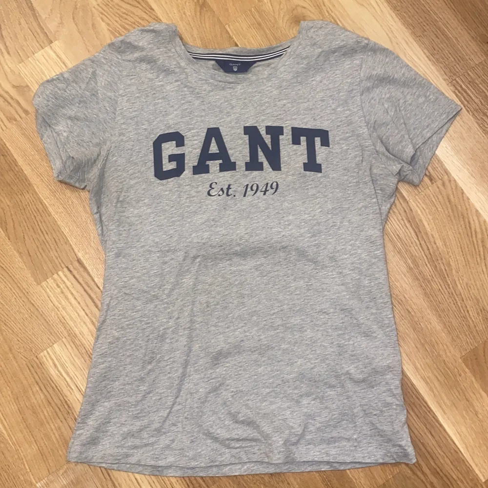 Grå T-shirt från GANT med marinblått tryck. Storlek XS. Knappt använd. T-shirts.