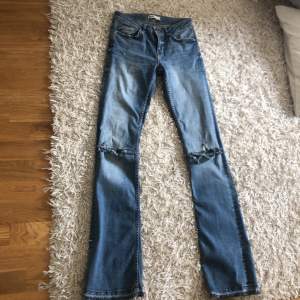 Ett par jättesnygga low waisted jeans i storlek 34. De har hål vid knäna och lite slitningar längst ner som är meningen! Använt ett par gånger, frakt ingår ej! Ginatricot