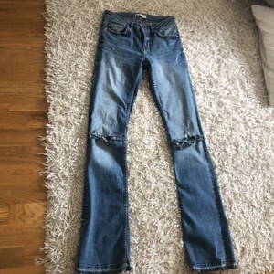 Low waisted jeans - Ett par jättesnygga low waisted jeans i storlek 34. De har hål vid knäna och lite slitningar längst ner som är meningen! Använt ett par gånger, frakt ingår ej! Ginatricot