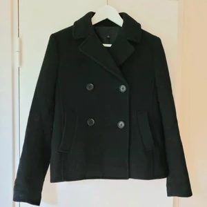 Ullkappa UNIQLO - Kort ullkappa/jacka från Uniqlo köpt i Japan. Passar vår, höst eller vinter! Material 35% ull, 34% polyester, 31% polyamid = varm. Fodrad, dubbel knäppning framtill samt fickor i sidorna. Storlek XS men passar även S. Skriv dm vid intresse💓 Slutpris: 360kr