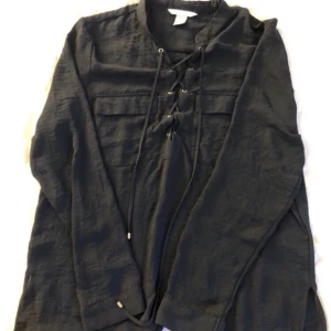 Snörad blus - Marinblå snörad blus vid brösten. Använd en gång. Bjuder på frakten