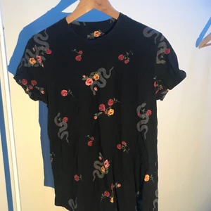 Hollister T-Shirt - En svart t-shirt med Hollister tryck i storlek small.