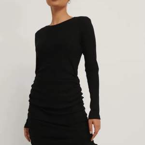 Oanvänd svart charmig klänning med dragsko från NA-KD i storlek Medium 