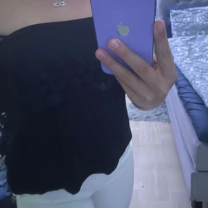 Sommartopp  - En svart enkel topp som blir lite mer uppklädd då det inte finns några band eller något sånt. Den sitter uppe me resårband som går precis över brösten. Den har ett litet mönster som gör den lite mer extra. Frakten tillkommer!