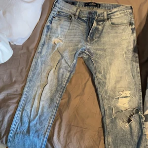 Hollistljusblå Hollister slitna jeans  - Ljusblåa slitna jeans från Hollister. De är använda men i bra skick. De är lite kortare i längden.