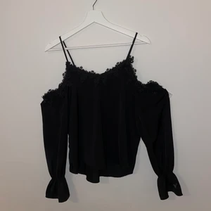 Blus  - En fin svart blus med spets och bara axlar, använd fåtal gånger. Frakt ingår i priset.