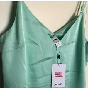 Lång grön satin klänning från Monki - Helt ny! Oanvänd med lapp kvar. Justerbart. Passar även en S eller L beroende på passform.  Strl M