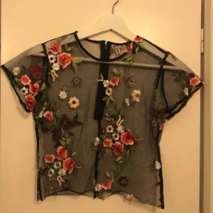 blommig mesh topp - en fin tshirt/magtröja att ha på sommaren! det står varken storlek eller märke men jag skulle tippa på S-M. behövs fler bilder är det bara att skriva :)