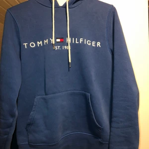 Blå HilfigerHoodie  - Snygg och bekväm hoodie från Tommy Hilfiger. Fint skick, skickar gärna fler bilder om så önskas💙 Köpt på Zalando för något år sedan men inte använd så jättemycket! Storlek S men passar även XS/M skulle jag säga 💙