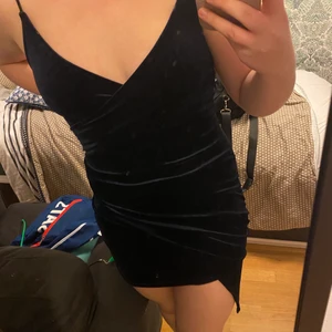 Mörkblå sammetsklänning ifrån Bikbok (S) - Mörkblå sammetsklänning ifrån bikbok i storlek s, skulle dock själv anse att en person som vanligtvis använder M i kläder lätt kan använda denna då jag tycker att den var lite stor i storleken. Själv gick jag ner en storlek (alltså gick jag från M till S) när jag köpte den för att få bäst passform (på mig). Klänningen är använd två gånger sedan 2019 och är i extremt bra skick. Ordinarie pris 400kr 